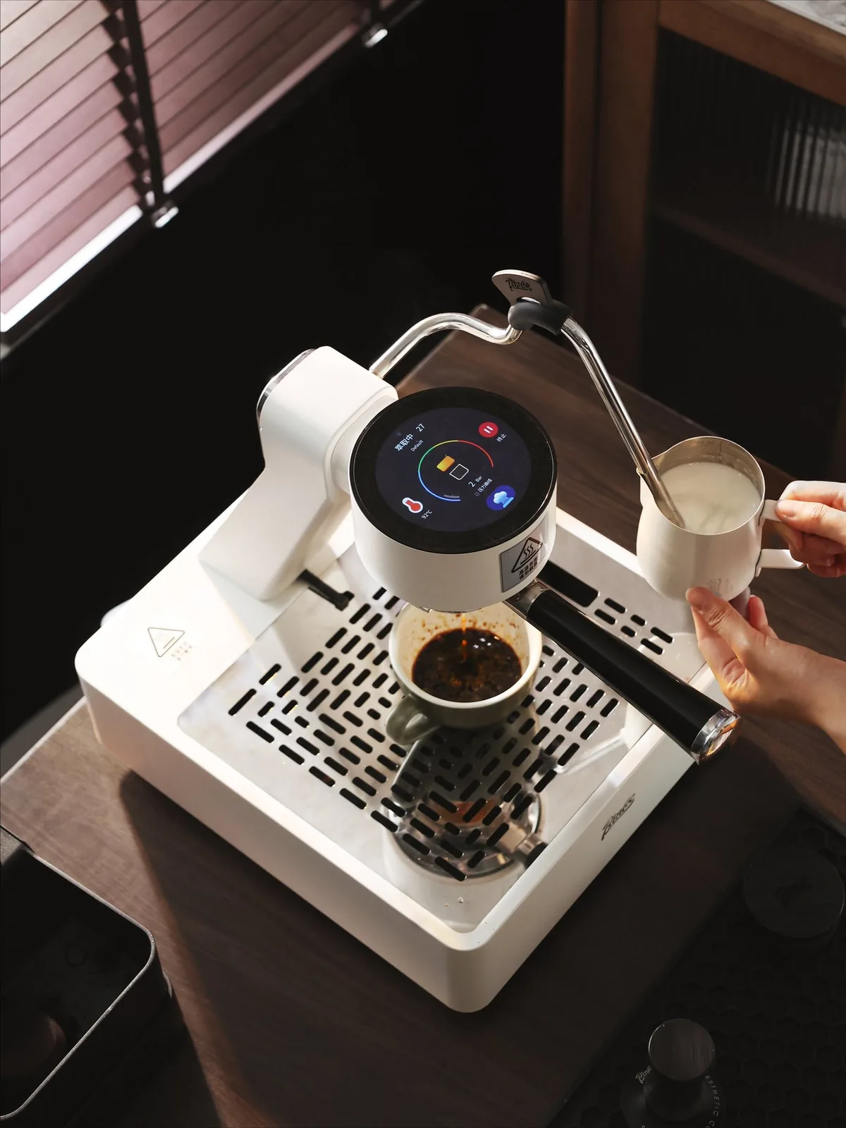 Barista steaming milk beside the Bincoo S2 Pro Trailblazer